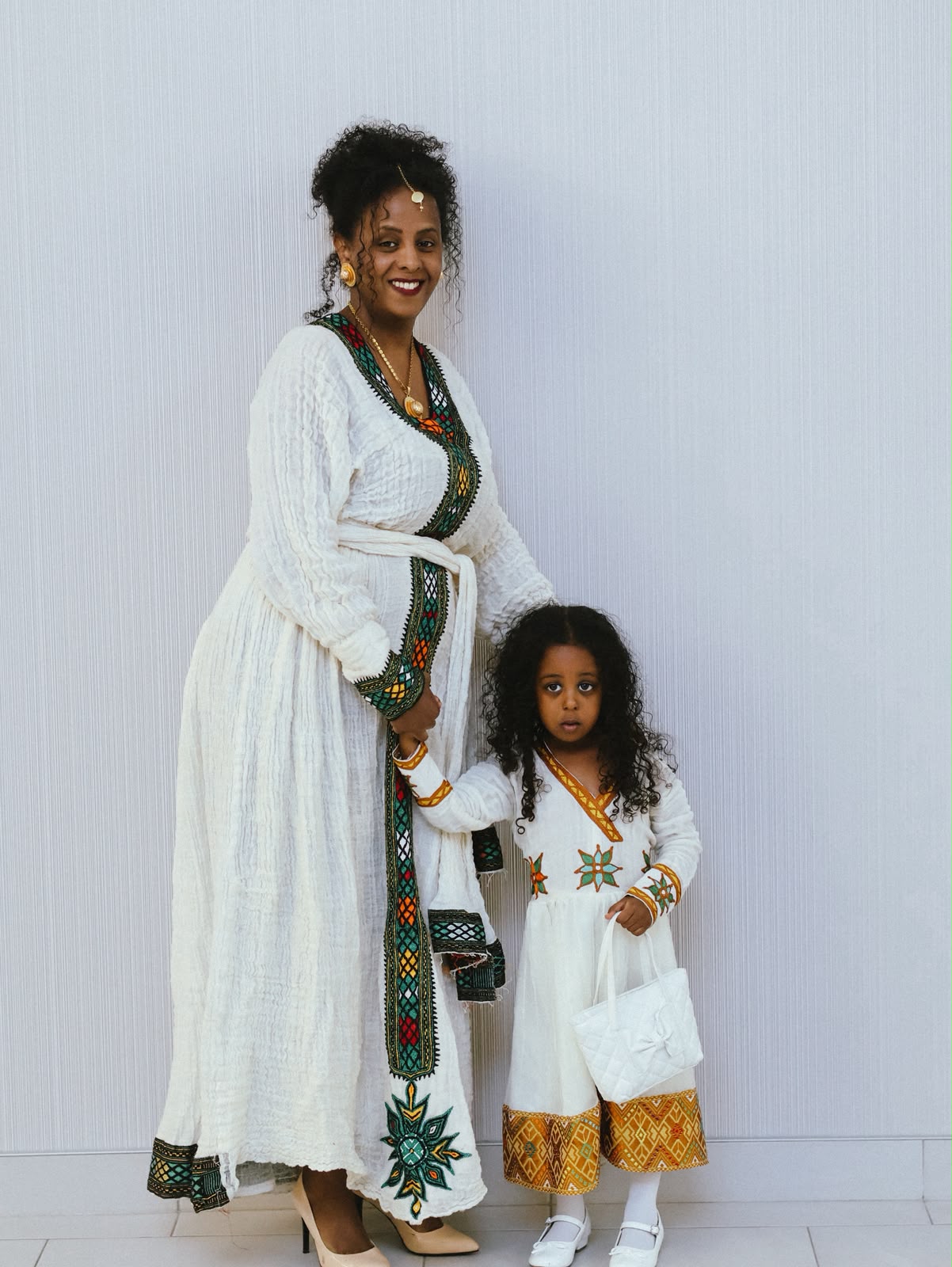 Mother and daughter in matching white embroidered dresses