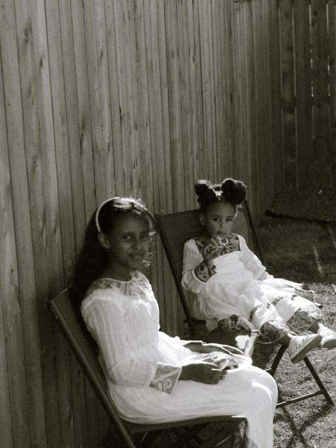 Two young girls sitting together, smiling