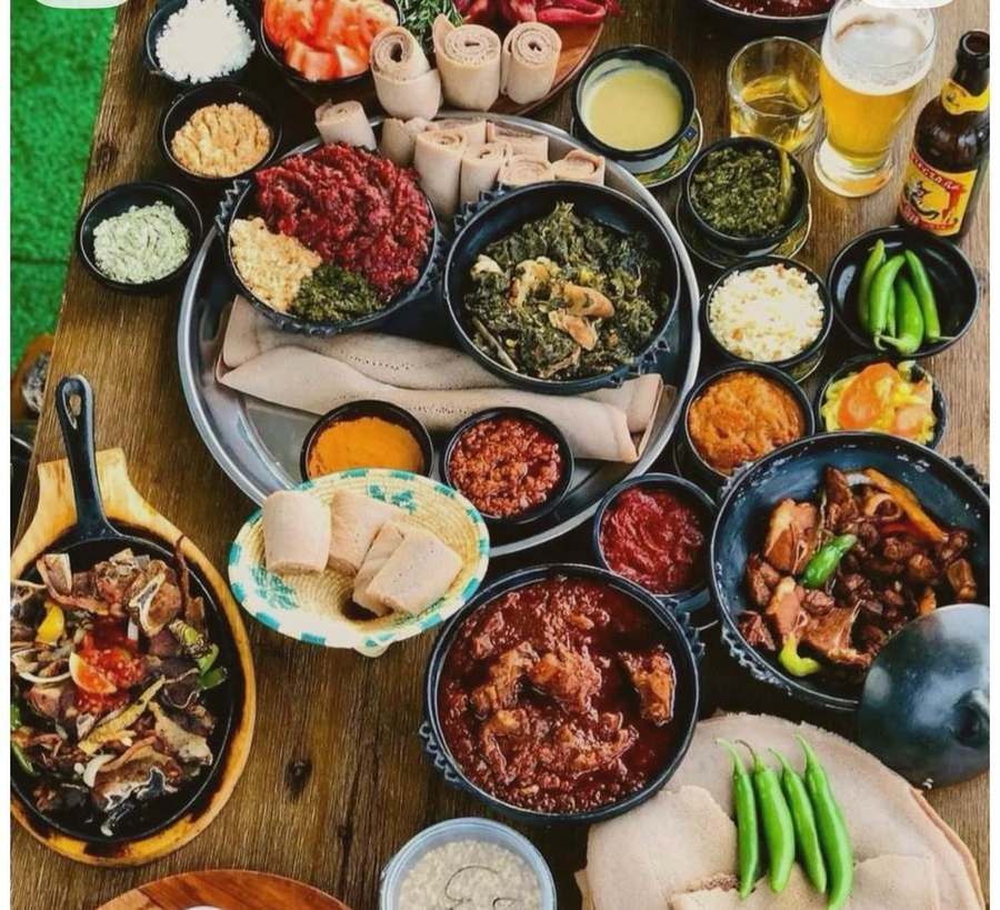 Full platter of injera with an assortment of stews and sides