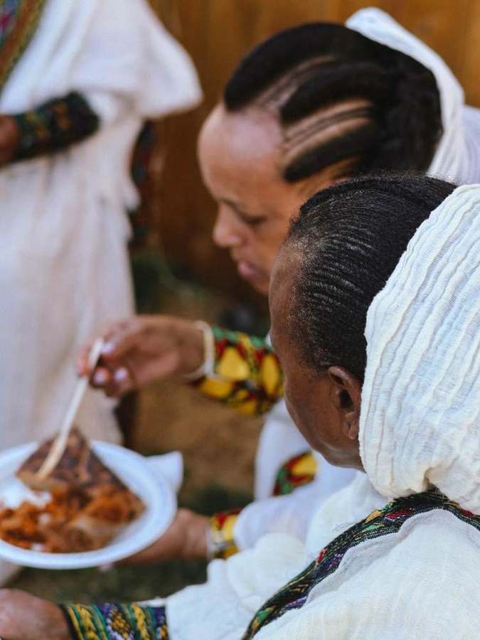 Serving a plate of injera and stew