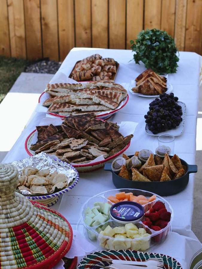 Table spread of breads, samosas, and fresh fruit