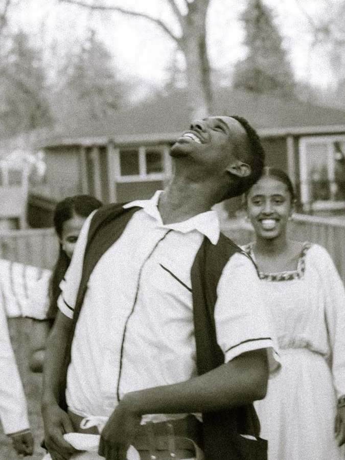 Young man laughing, walking with friends