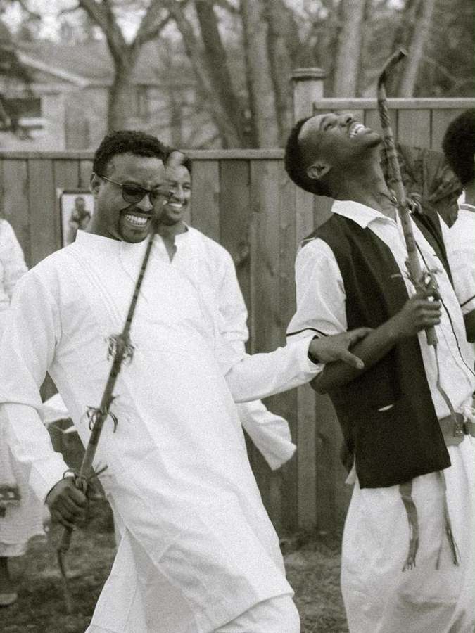 Men dancing with sticks, laughing together