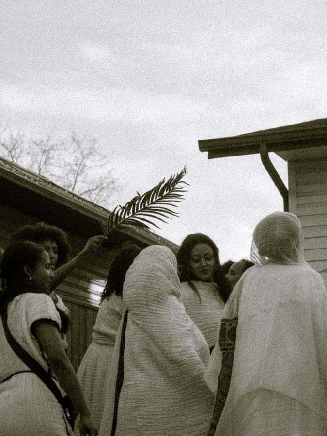 Guests gathered under a raised palm branch