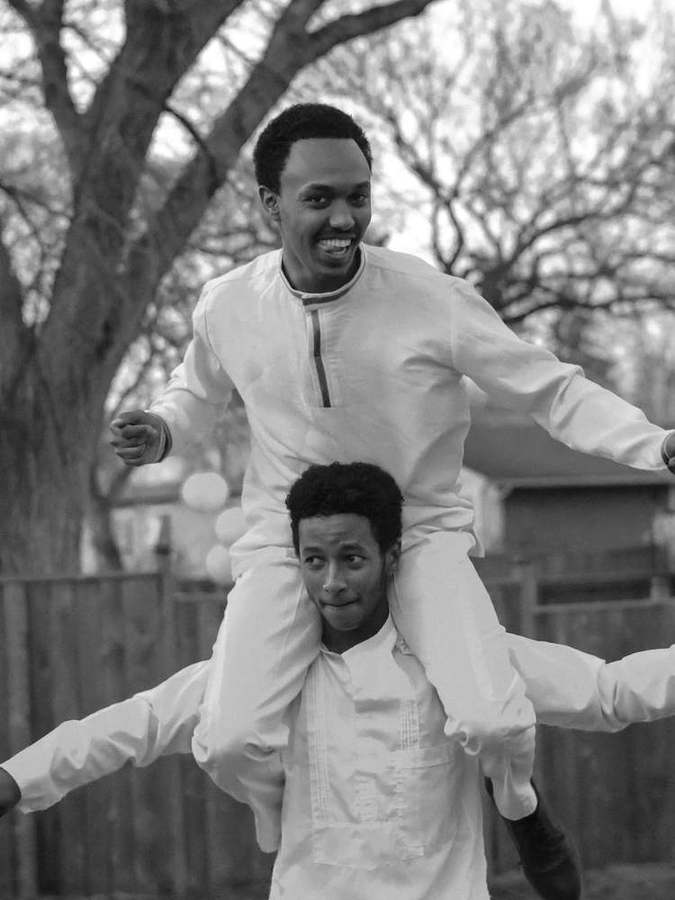Two friends dancing, one carried on the other's shoulders