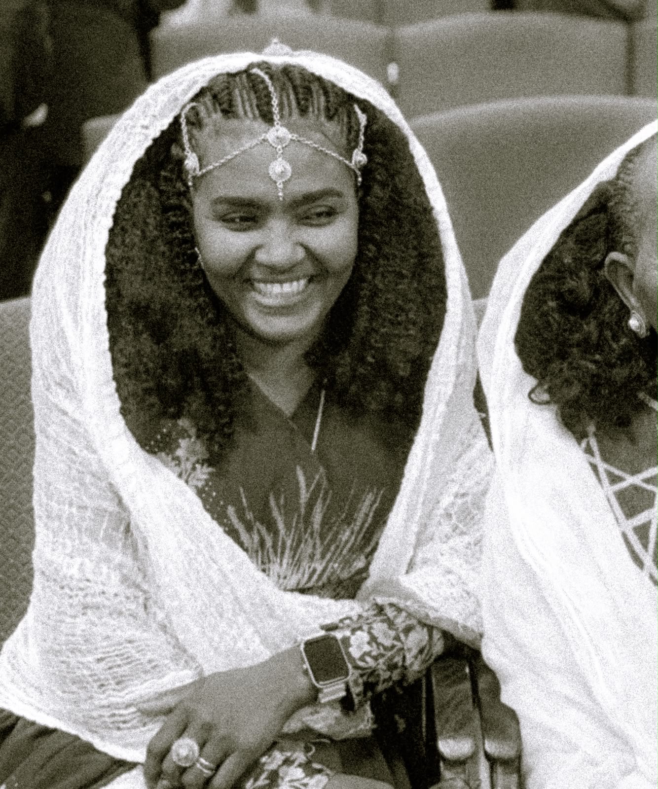 Woman in a patterned dress and lace headscarf