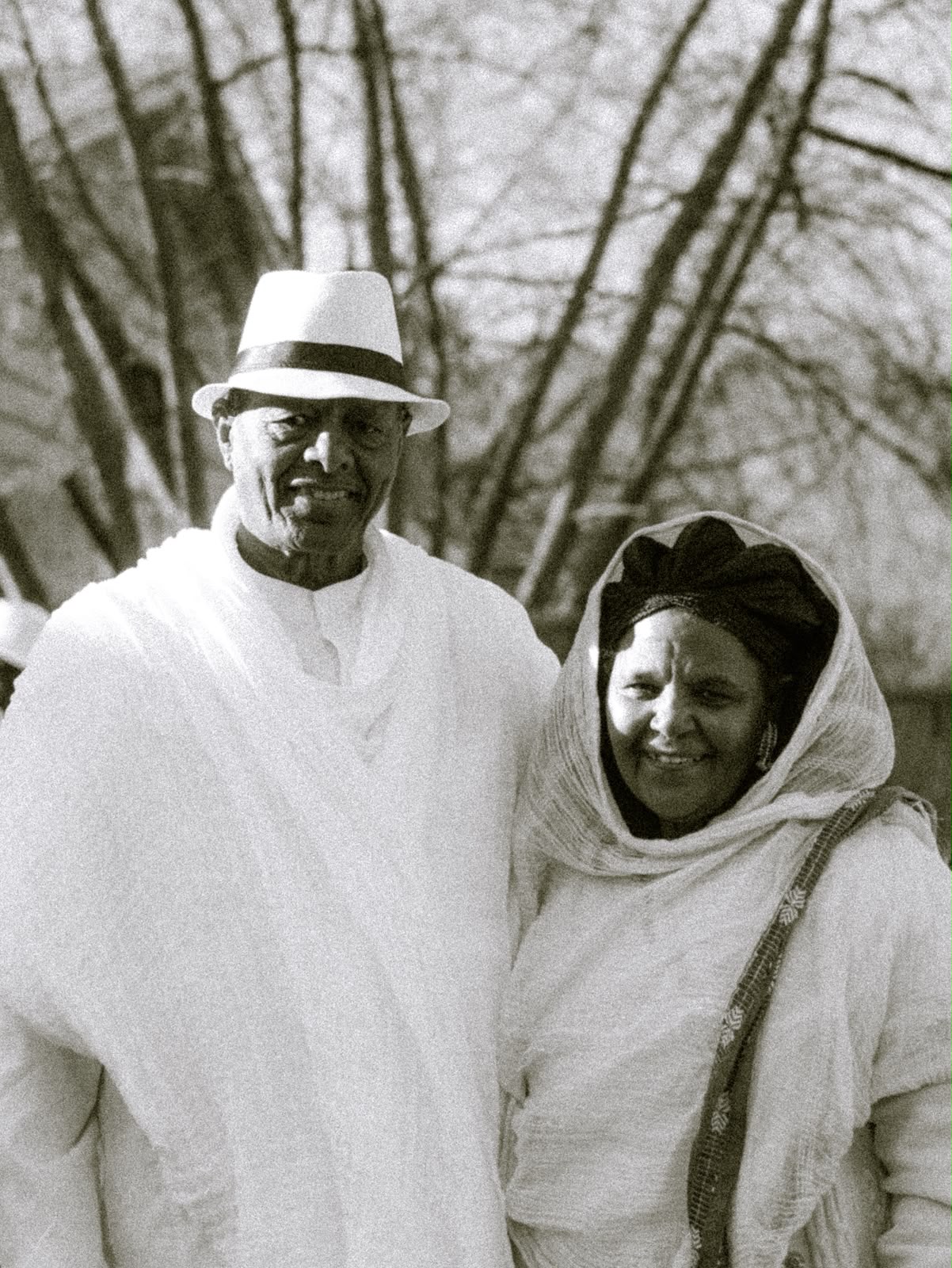 Elder man in a white hat and woman in a headscarf smiling together