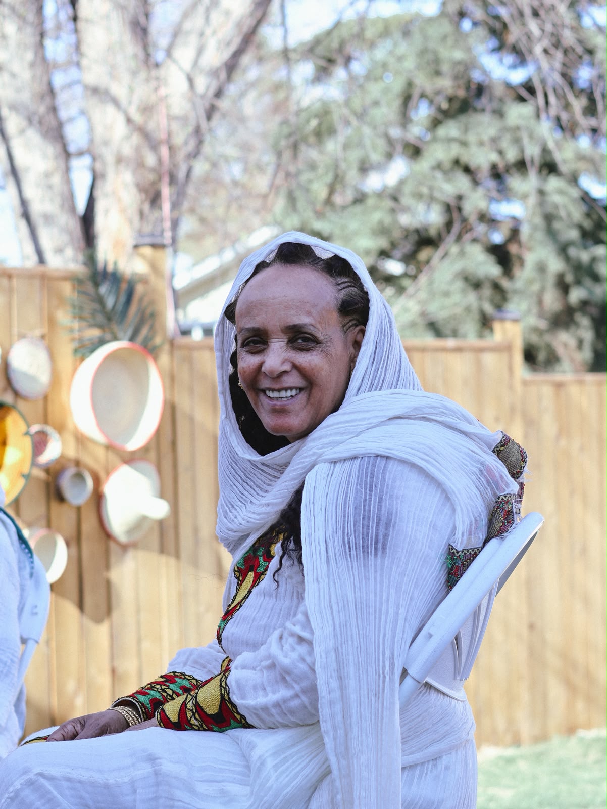 Woman smiling over her shoulder, seated by the woven basket display